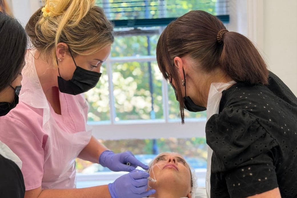Tutor supervising facial marking during practical filler training